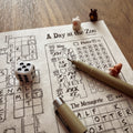 A Day at the Zoo game in progress with a die, a pen and animal figures