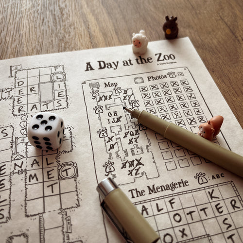 A Day at the Zoo game in progress with a die, a pen and animal figures